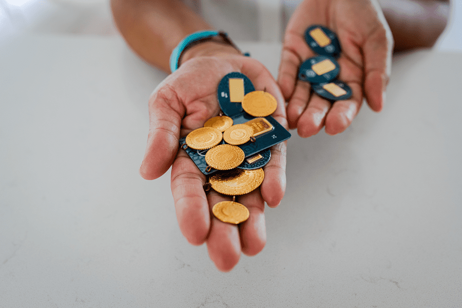Hands holding gold coins and circuit boards.