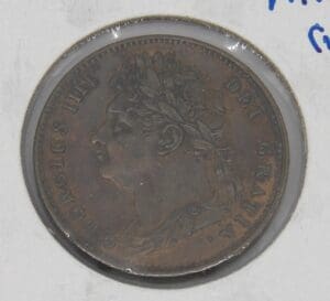 Close-up of an old coin with a profile of a figure wearing a laurel wreath.