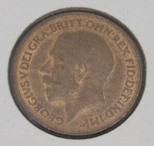 Close-up of a coin featuring a king's profile and inscription.